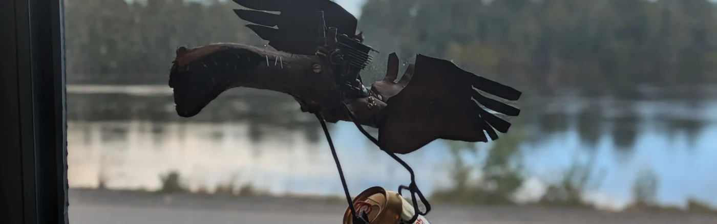 Skulptur i plåt av fågel med ölburk
