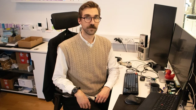 Bild på Pontus Hedenström sittande vid skrivbordet på sin arbetsplats