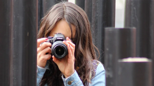 Photo of Kim Onchoi Stenmark looking through a camera