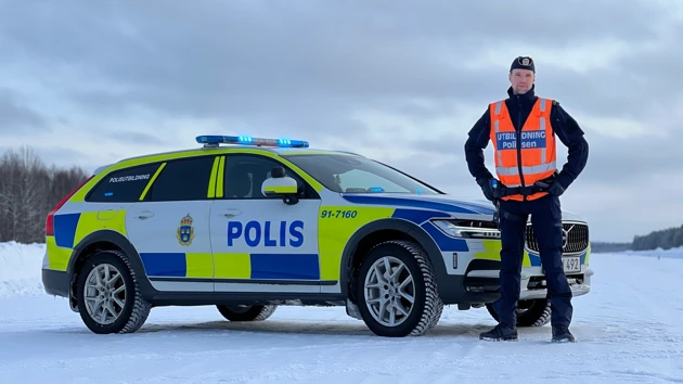 Robin står bredvid en polisbil i vintermiljö.
