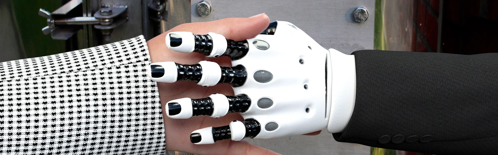 Närbild på robothand skakar hand med en människa.