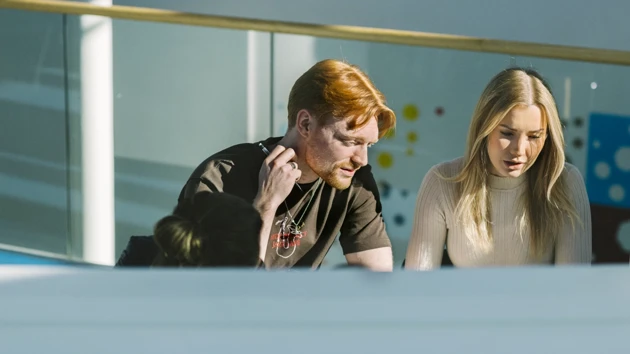 Två studenter har hittat en solig plats att jobba med sitt grupparbete på.