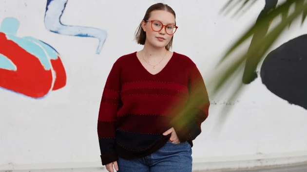 Student som står framför en vägg i Lindellhallen. 