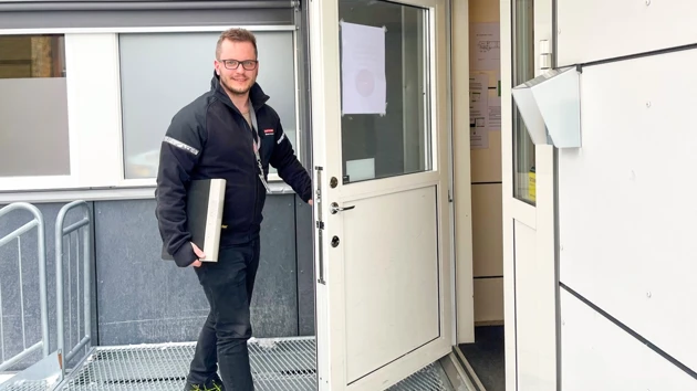 Bild på Simon på väg in genom dörren på sin arbetsplats
