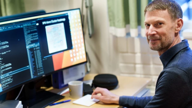 Portrait photo of Nathaniel Street sitting by the computer
