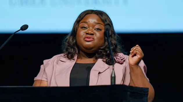 Student speaking at a graduation ceremony in front of a podium.