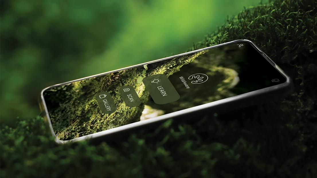 A cell phone sitting on top of a lush green field.