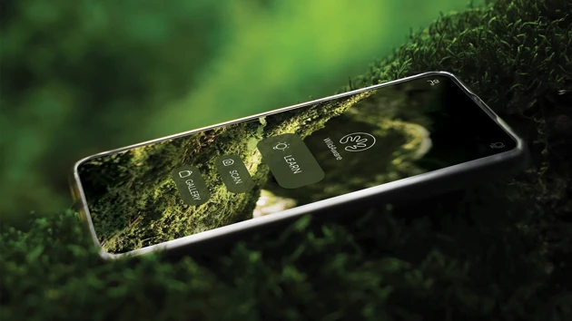 A cell phone sitting on top of a lush green field.