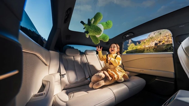 A little girl sitting in the back seat of a car.