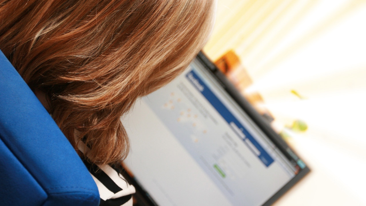 Person som sitter med dator och ska logga in på Facebook.