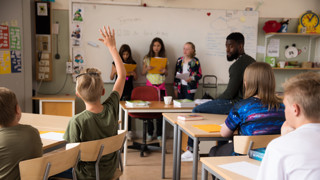 Barn i klassrum som redovisar för lärare och klasskompisar.