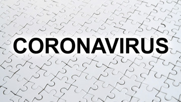 Ordet Coronavirus skrivet ovanpå ett vitt pussel.