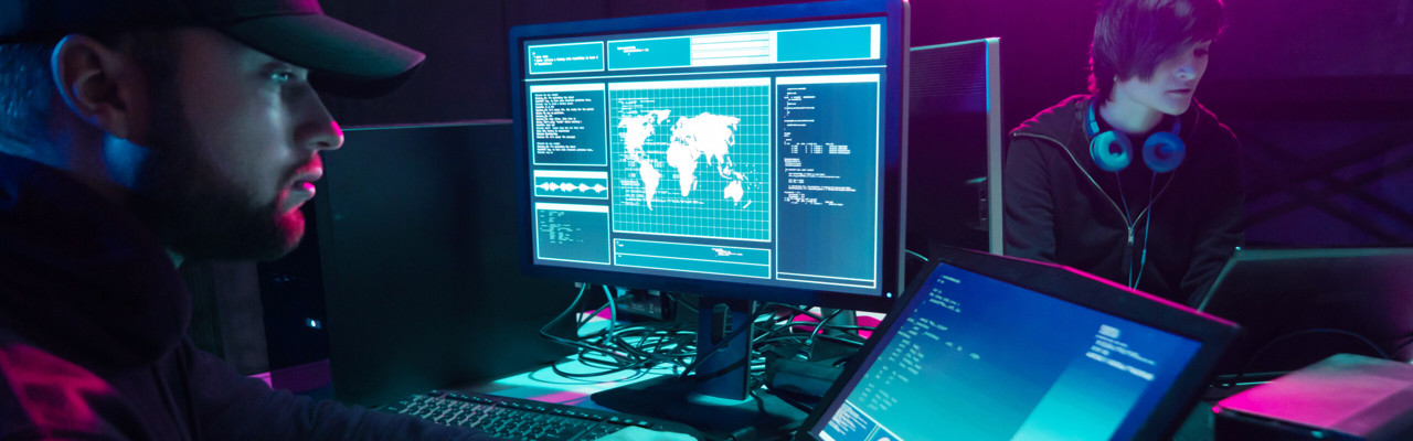 Bilden visar flera datorskärmar där man ser att någon programmerar