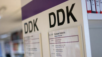 DDK-skylt på en av bibliotekets hyllgavlar