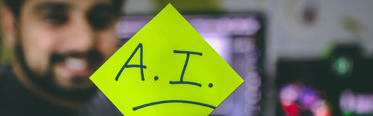 A man holding a sign with the text "AI"