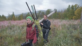 Forskare bär på utrustning för fältstudier i Lapplandsfjällen.