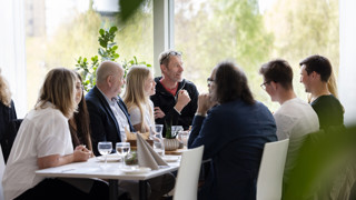 Rektor Hans Adolfsson och vicerektor Dieter Muller äter lunch tillsammans med de elitidrottsstudenter som vunnit en EM- eller VM-medalj under år 2022 och 2023.