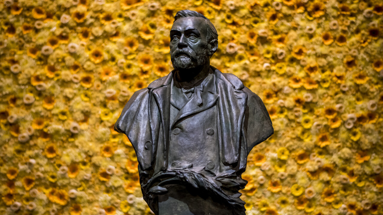 Bild på byst av Alfred Nobel med blommor i bakgrunden