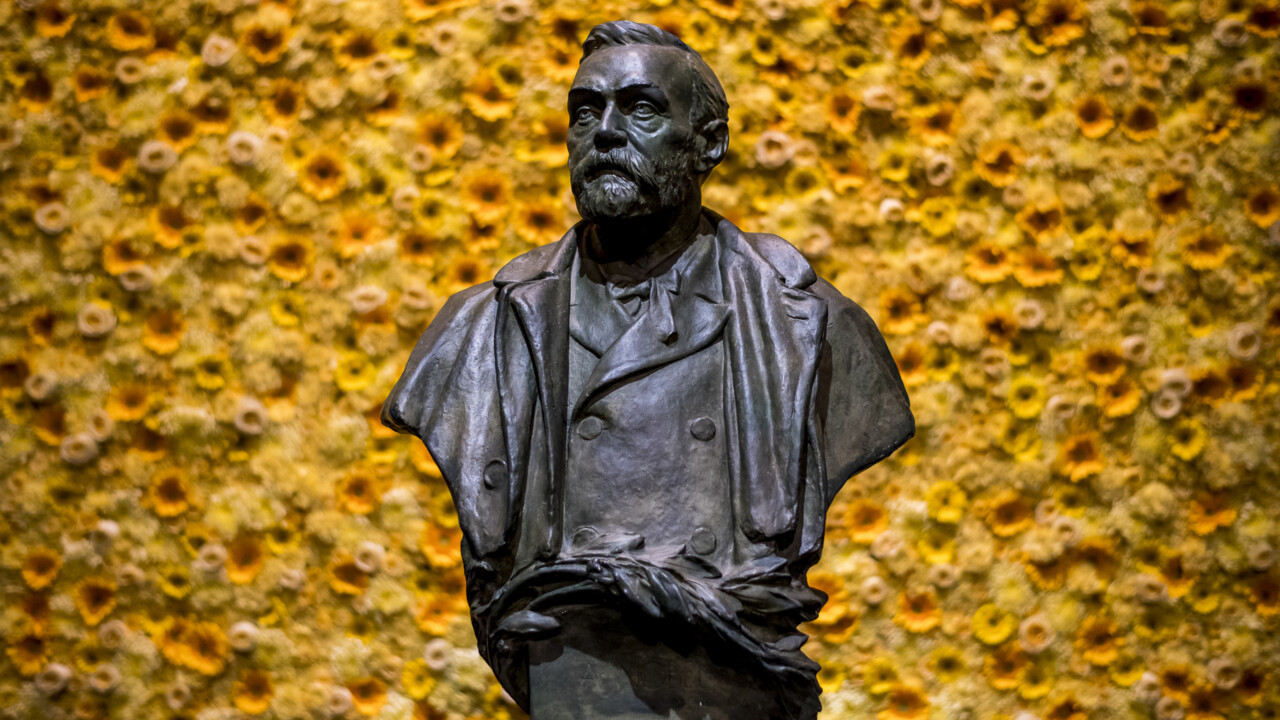 Bild på byst av Alfred Nobel med blommor i bakgrunden