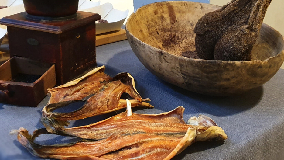 Bild på torkad fisk, en traditionell kaffekvarn och en torkad renmage