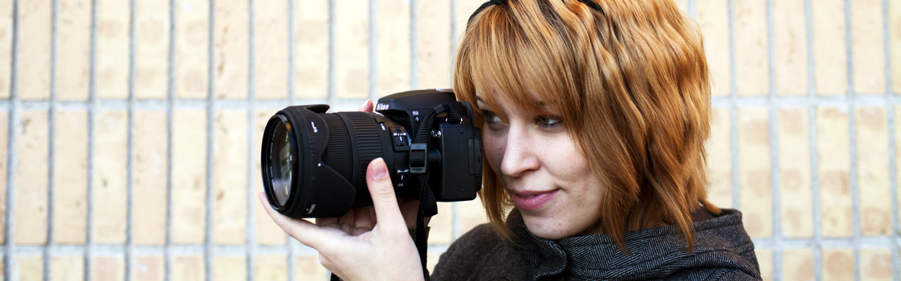 En person fotograferar med en systemkamera.