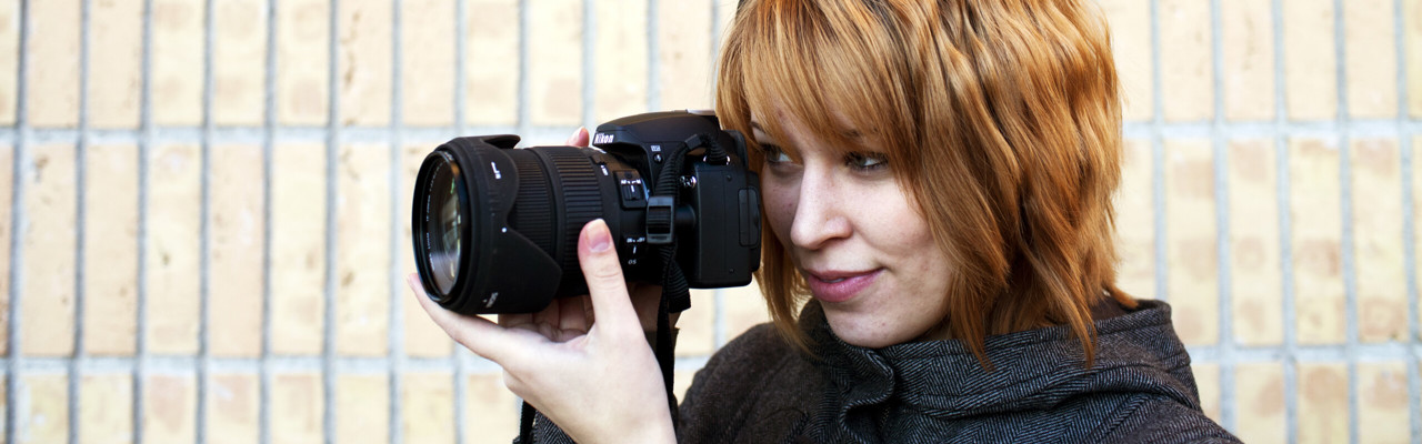 En person fotograferar med en systemkamera.