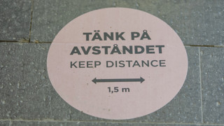 Klistermärke med texten "Tänk på avståndet, Keep distance, 1,5 m." på golvet i Handelshögskolans fik under pandemin 2021.