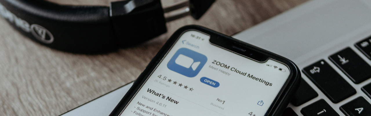 Dator, hörlurar och mobil med zoom-app.