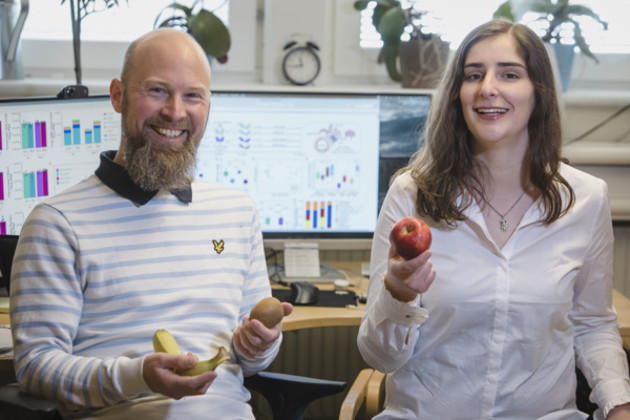 Researchers holding fruit in office. Umeå University.