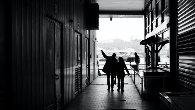 Couple silhouettes walking on narrow passage of modern building_Furkanfdemir